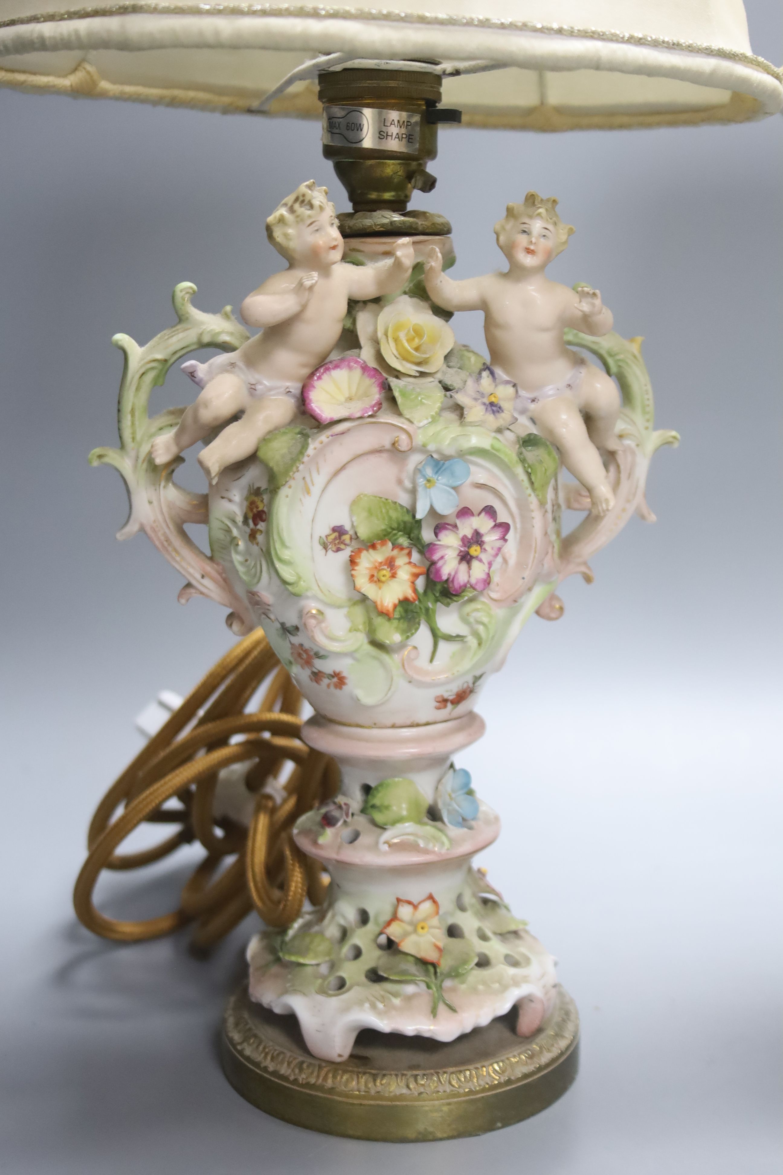 A pair of German porcelain flower encrusted lamps, height 24cm